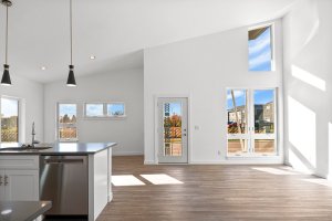 Open concept living room with large windows, natural light, and modern finishes in a new construction home in Wisconsin